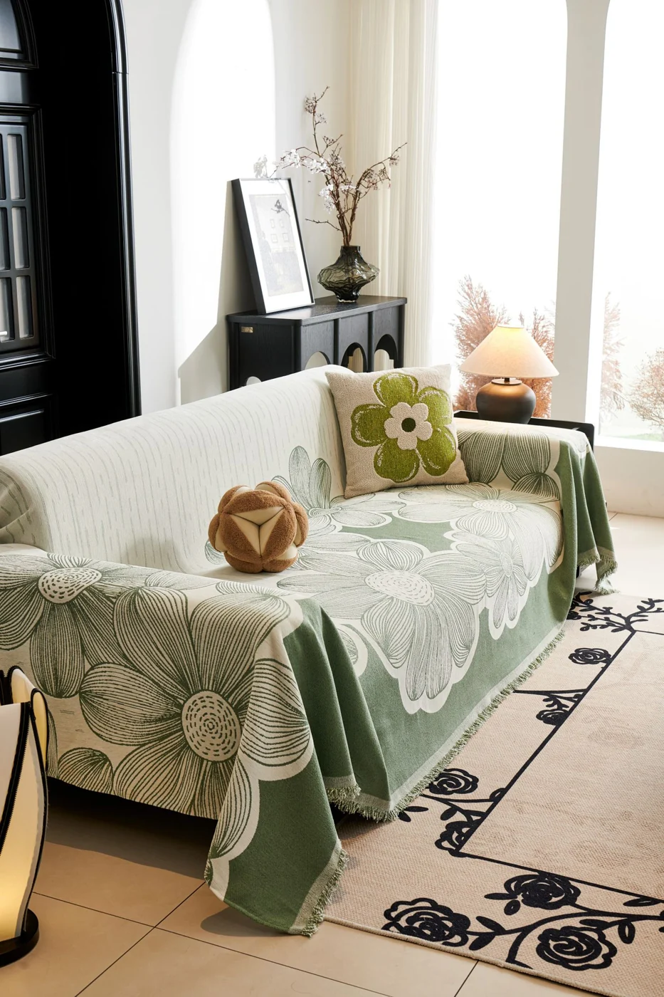 Stylish living room featuring a floral sofa cover and decorative cushions, bathed in natural light.