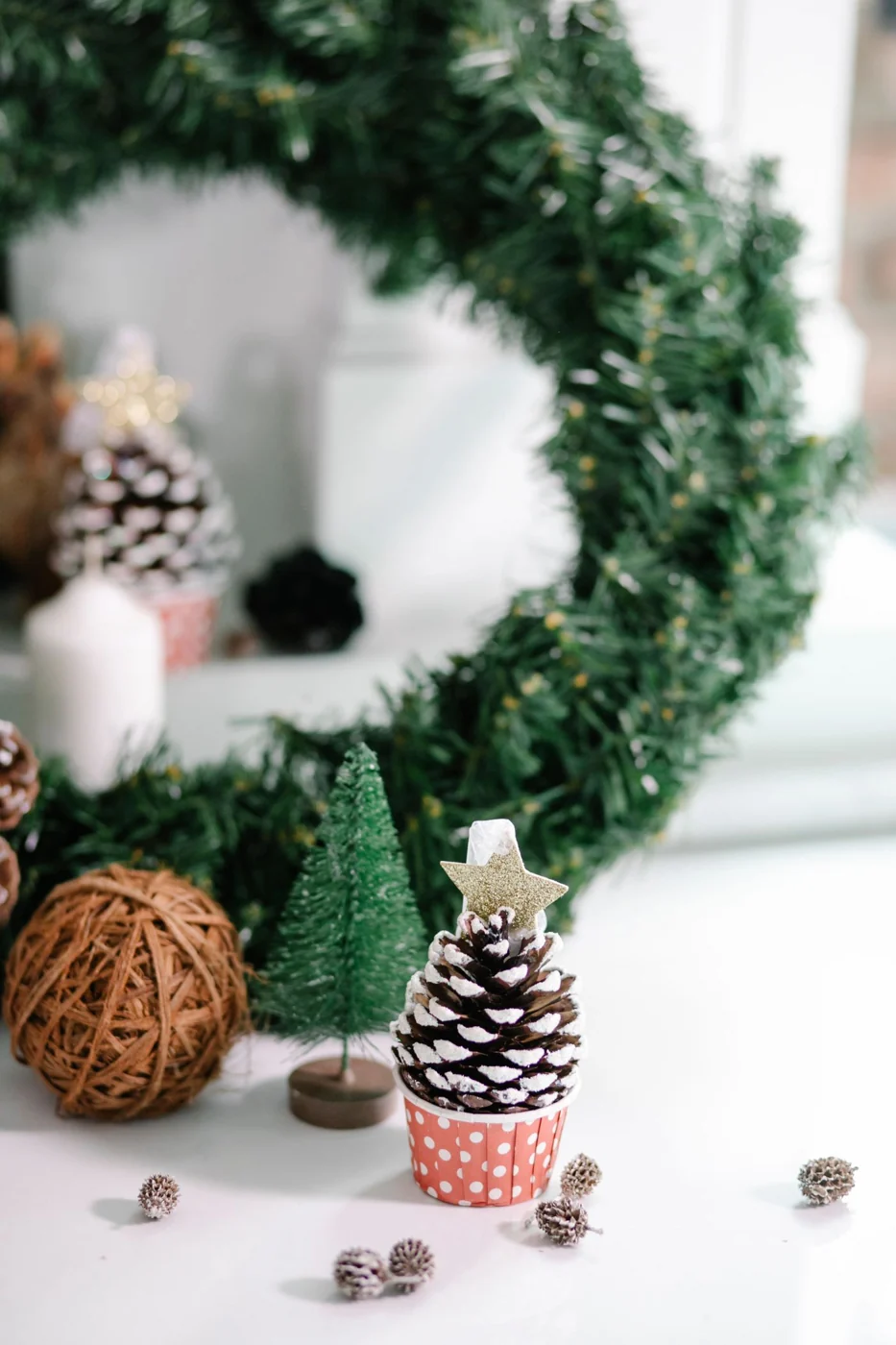 Cozy indoor holiday scene featuring decorative pine cone, wreath, and festive elements.