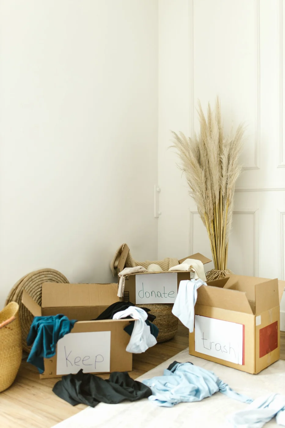 Boxes labeled keep, donate, and trash for efficient home decluttering and organization.